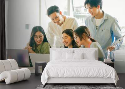 Asian business people are looking at their business plans together on their laptop screens Wall mural