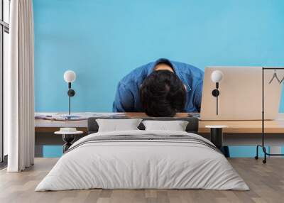 Asian businessman dropped his head on the table because of the pressure at work Wall mural