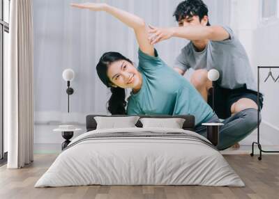 Asian couple doing yoga together at home Wall mural