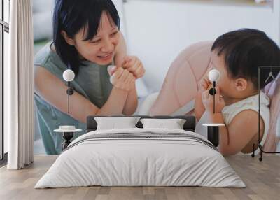 Asian woman coaxing her child to eat lunch
 Wall mural