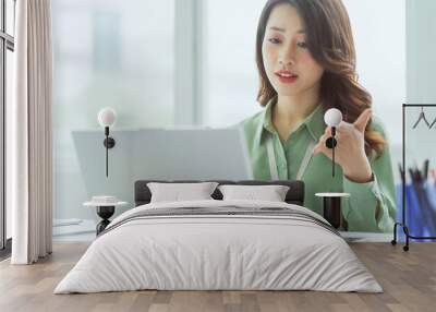 Beautiful Asian businesswoman sitting working at office Wall mural