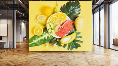 Chopped tropical fruit in bowls and plates Wall mural