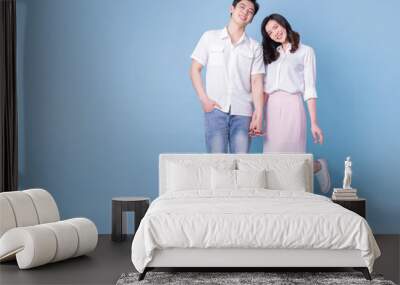 Full length image of young Asian couple on blue background Wall mural