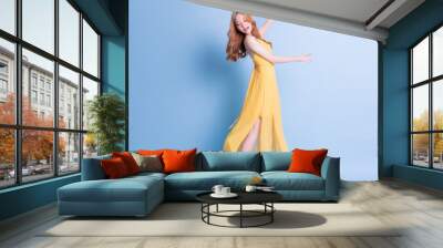 full length image of young asian woman wearing yellow dress on blue background Wall mural