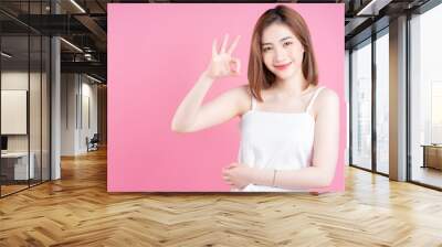 Image of young Asian woman posing on pink background Wall mural