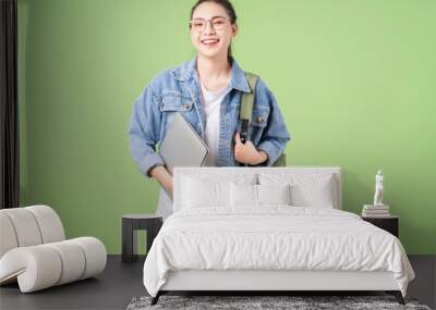 Photo of young Asian college girl on green background Wall mural