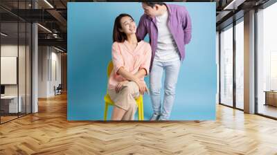 Photo of young Asian couple on blue background Wall mural