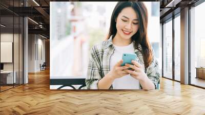 Portrait of young Asian woman using smartphone at home Wall mural