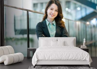 Portrait of young businesswoman standing in corporate corridor Wall mural