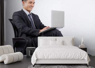 Young Asian businessman sitting on chair on white background Wall mural