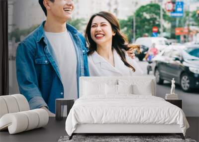 Young Asian couple walking on the street Wall mural