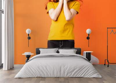 Young asian girl jumping up on orange background Wall mural