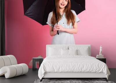 Young Asian woman holding umbrella on pink background Wall mural