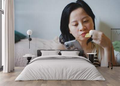 Young Asian woman using smartphone at home Wall mural