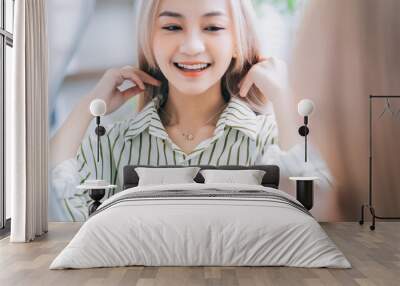 Young Asian woman wearing jewelry in front of mirror Wall mural