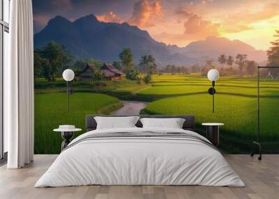 A large green rice field with a beautiful farmhouse, clear river water flowing nearby, towering trees, and distant mountains under a vibrant sunset sky Wall mural