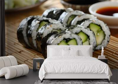 A refreshing cucumber and avocado sushi roll, neatly sliced and served with soy sauce and pickled ginger on a bamboo mat Wall mural