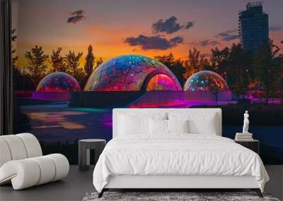 A vibrant sunset over a public park featuring a concrete dome, illuminated by colorful LEDs and dynamic video projections Wall mural