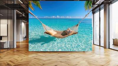 A photostock image of a tropical beach with a hammock between two palm trees and clear turquoise water Wall mural