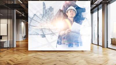 The double exposure image of the engineer standing back during sunrise overlay with cityscape image. The concept of engineering, construction, city life and future. Wall mural