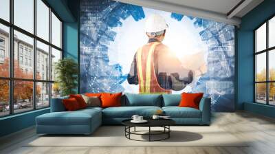 The double exposure image of the engineer standing back during sunrise overlay with cityscape image. The concept of engineering, construction, city life and future. Wall mural