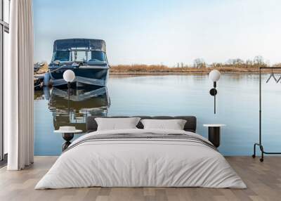 Fishing boats moored at wooden pontoon pier in early morning. Modern motorboats in small docks on calm river. Wide angle shot Wall mural