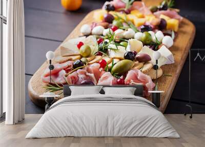 Antipasto platter with ham, prosciutto, salami, cheese,  crackers and olives on a wooden background.  Christmas table. Wall mural