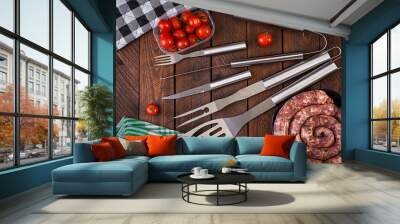 Barbecue Tools and sausage on wooden table. Flat lay, top view Wall mural