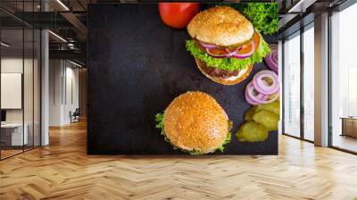 Big sandwich - hamburger burger with beef, pickles, tomato and tartar sauce on black background. Top view Wall mural