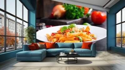 Classic italian pasta penne alla arrabiata with basil and freshly grated parmesan cheese on dark table. Penne pasta with chili sauce arrabbiata. Wall mural