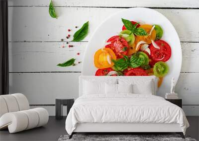 Colored tomato salad with onion and basil pesto. Vegan food. Top view. Flat lay Wall mural