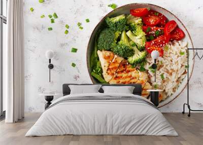 Delicious buddha bowl with grilled chicken, fresh vegetables and rice on a light background. Top view, above Wall mural