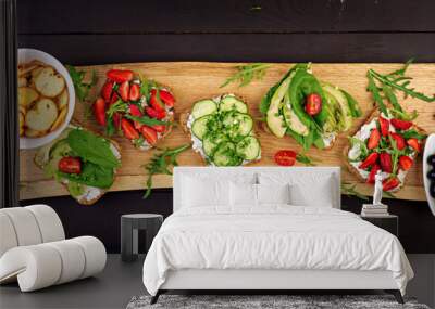 Flat lay of healthy vegetarian dinner table setting. Sandwiches with tomato, cucumber, avocado, strawberry, herbs and olives, snacks. Banner. Clean eating, vegan food Wall mural