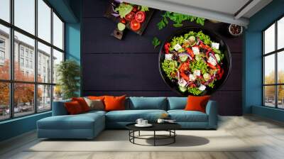 Healthy food. Greek salad with cucumber, tomato, sweet pepper, lettuce, red onion, feta cheese and olives.  Top view, copy space Wall mural