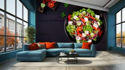 Healthy food. Greek salad with cucumber, tomato, sweet pepper, lettuce, red onion, feta cheese and olives.  Top view, copy space Wall mural