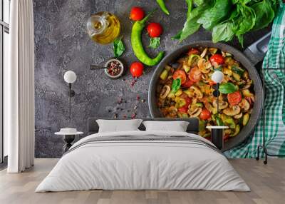 Hot spicy stew eggplant, sweet pepper, tomato, zucchini and mushrooms. Flat lay. Top view Wall mural