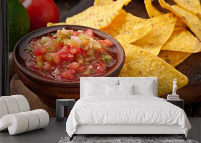 Mexican nacho chips and salsa dip in bowl on wooden background Wall mural