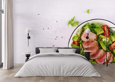 Tuna salad. Japanese traditional salad with pieces of medium-rare grilled Ahi tuna and sesame with fresh vegetable on a bowl. Authentic Japanese food. Top view Wall mural