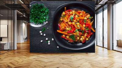 Vegetable stew of chickpeas, carrot, sweet peppers, onions, garlic and tomato sauce with lemon on the dark table. Oriental cuisine. Top view Wall mural