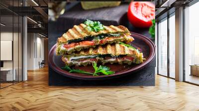 Vegetarian sandwich panini with spinach leaves, tomatoes and cheese on a dark table. Toast with cheese. Wall mural