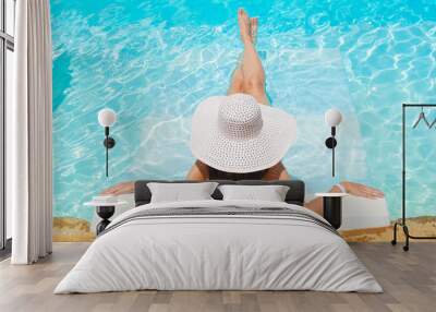 beautiful woman white hat and bikini lying in a pool Wall mural