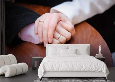 bride holding the groom's hand on the table Wall mural