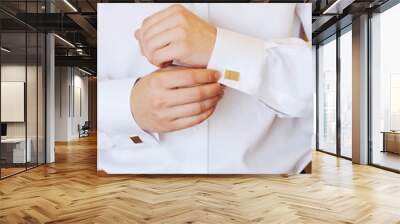 man puts cufflinks on sleeve white shirts Wall mural