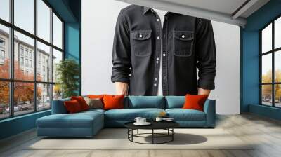 A stylish man wearing a black button-up shirt over a white t-shirt stands with arms crossed. The casual yet sophisticated look is ideal for modern fashion inspiration. Wall mural