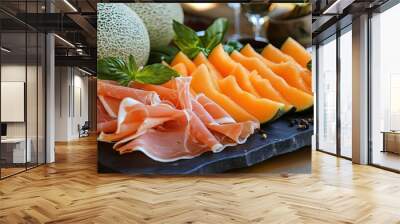 Delicious platter of ripe cantaloupe paired with savory prosciutto, garnished with fresh mint, perfect for summer gatherings. Wall mural