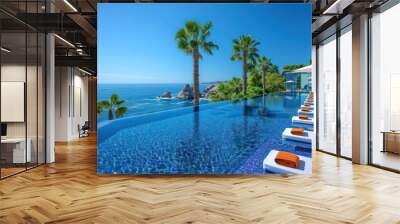 Luxurious swimming pool and loungers umbrellas near beach and sea with palm trees and blue sky Wall mural