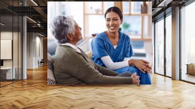 Healthcare, happy and a nurse talking to an old woman in a nursing home during a visit or checkup. Medical, smile and a female medicine professional having a conversation with a senior resident Wall mural