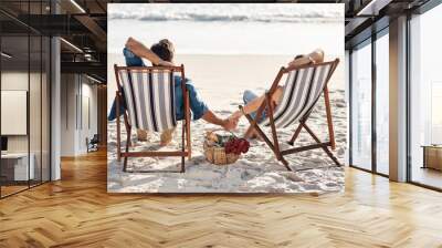 Tranquility is what were after. Rearview shot of a middle aged couple sitting in their beach chairs on the the beach. Wall mural