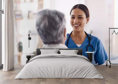 Healthcare, happy and a nurse talking to an old woman about treatment in a nursing home facility. Medical, smile and a female medicine professional chatting to a senior resident during a visit Wall mural