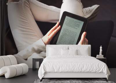 Woman sitting by the window with an e-book Wall mural